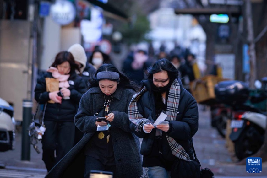 1月9日，在韓國(guó)首都首爾，人們?cè)诘蜏刂谐鲂?。新華社發(fā)（樸晉澤攝）